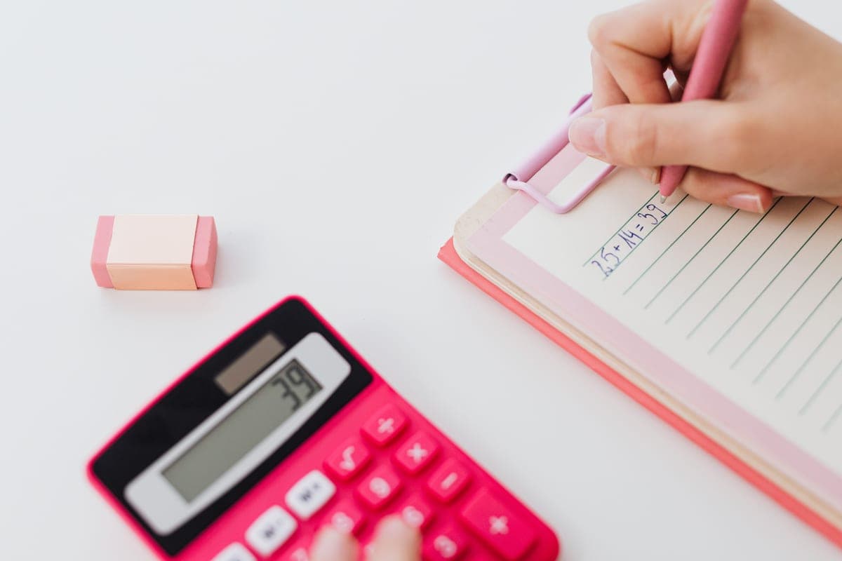 A calculator and notebook on a desk, used for working out grow light coverage